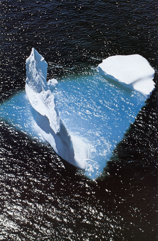 Арктический айсберг, плывущий на юг в водах Ньюфаундленда. Айсберги образуются, когда язык ледника сползает в море и его передний край раскалывается на куски. Некоторые арктические айсберги имеют по нескольку сот метров в диаметре и возвышаются над водой больше чем на 100 м. Однако основная часть - до девяти десятых - их массива скрыта под водой